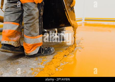 epoxy flooring applicator performs painting works with polyurethane epoxy mortar Stock Photo