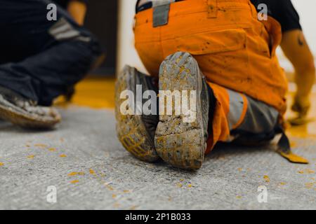 epoxy flooring applicator performs painting works with polyurethane epoxy mortar Stock Photo