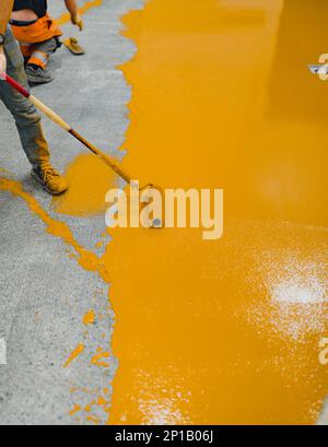 epoxy flooring applicator performs painting works with polyurethane epoxy mortar Stock Photo