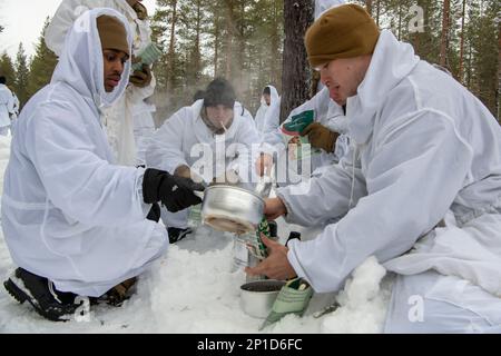 U.S. Army Soldiers with Charlie Troop, 3-71st Cavalry Regiment, 1st Brigade Combat Team, 10th Mountain Division, prepare Finnish meals ready to eat during Arctic Forge 23 on Sodankylä Garrison, Finland, Feb 18, 2023. Exercise Arctic Forge 23 is a U.S. Army Europe and Africa led umbrella exercise that leverages the host nation exercises Defense Exercise North in Finland, and exercise Joint Viking in Norway, taking place Feb. 16 through March 17, 2023, focused on building capabilities and cooperation in support of the U.S. Army’s Arctic Strategy. Stock Photo