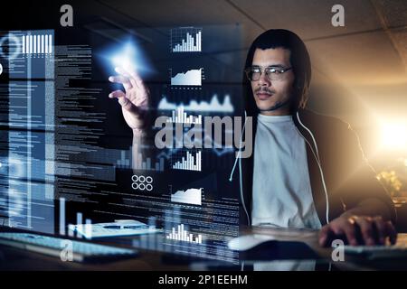 Hackers are the masters of stealth. Shot of a young hacker cracking a computer code in the dark. Stock Photo