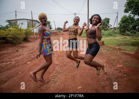 Three happy African girls jump and laugh, friendship and togetherness concept Stock Photo
