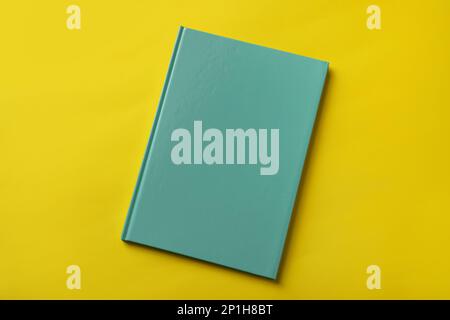 New stylish planner with hard cover on yellow background, top view Stock Photo