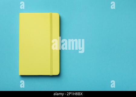 New stylish planner with hard cover on light blue background, top view. Space for text Stock Photo