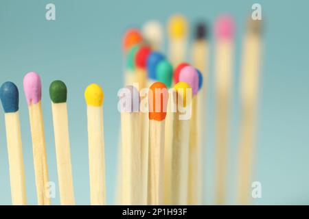 Matches with colorful heads on light blue background, closeup Stock Photo