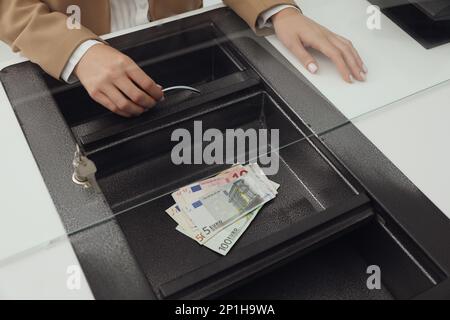 Cashier with money at bank, closeup. Currency exchange Stock Photo