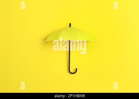 Bright toy umbrella on yellow background, top view Stock Photo