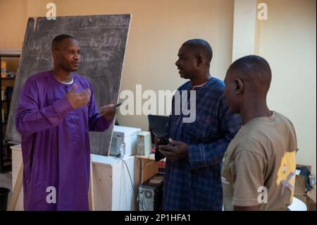 A staff member (left) of the American Cultural Center, Agadez, Niger, and members of the Niger Armed Forces (FAN), Affair Civil Militaire (ACM), discuss building an ongoing partnership between the center and the FAN Jan. 14, 2023. The 443 Civil Affairs Battalion, from AB 201, facilitated the meeting and then attended an English discussion group afterwards. Stock Photo