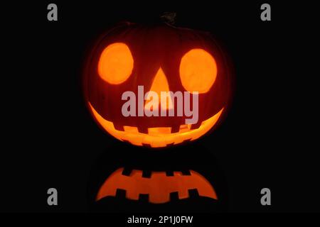 Jack O' Lantern reflecting on a black surface. Stock Photo