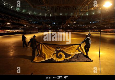 Workers removing Rams banners from the Edward Jones Dome