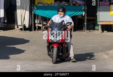 SAMUT PRAKAN, THAILAND, FEB 13 2023, A man rides a motorcycle at market Stock Photo