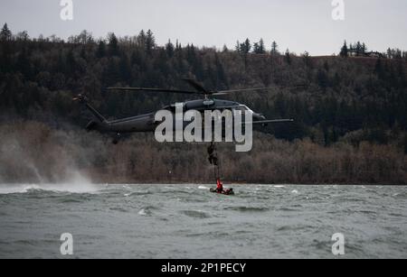 304th Rescue Squadron pararescuemen ascend a rope ladder connected to an HH-60G Pave Hawk operated by the 305th Rescue Squadron, during a rescue training scenario in the Columbia River Gorge, near Corbett, Ore., January 12, 2023. The two 943d Rescue Group, Davis-Monthan Air Force Base, Arizona, units carried out various rescue scenarios, ensuring Airmen are able to perform search and rescue operations in a variety of conditions and environments. Stock Photo