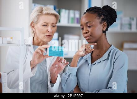 Healthcare, help and black woman with medicine from a pharmacist, dosage information and recommendation. Medical, sick and doctor reading label on a Stock Photo