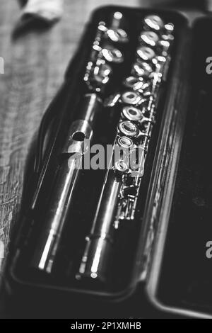 Black and white portrait of a music case with a disassembled metal silver flute in it with valves to play notes. the musical instrument will need to b Stock Photo