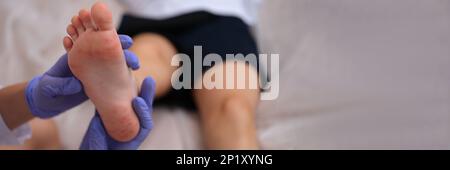 Infectious disease doctor examining rash on skin of child feet closeup Stock Photo