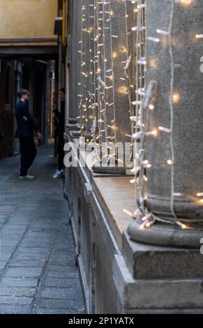 Couple takes a break and chats in the streets of Venice. Blurred background and soft lights on the buildings in the historic center. Stock Photo