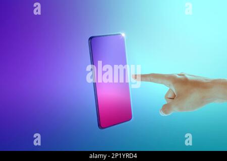 Human hand pointing mobile phone screen on a colored background Stock Photo