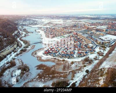 Aerial drone. Ebbsfleet garden city in Kent, covered in snow in December 2022. New developments and frozen lake alongside the A2 motorway. Stock Photo