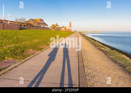 Shadow of a couple holding hands on the dike in Wilhelmshaven, Germany Stock Photo
