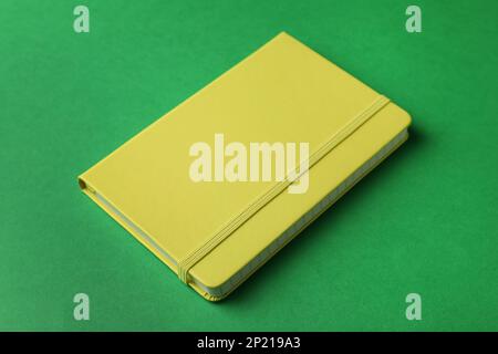 New stylish planner with hard cover on green background Stock Photo