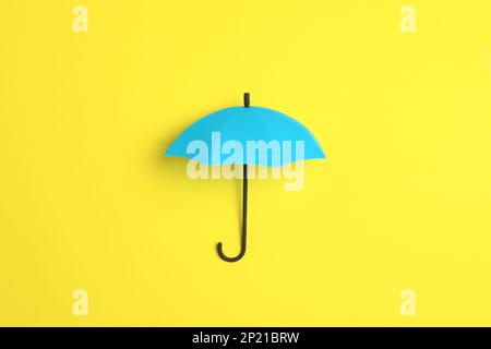 Bright toy umbrella on yellow background, top view Stock Photo