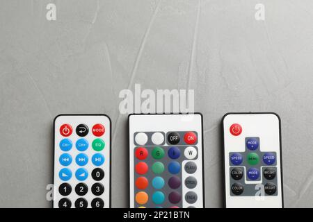 Remote controls on grey table, flat lay. Space for text Stock Photo
