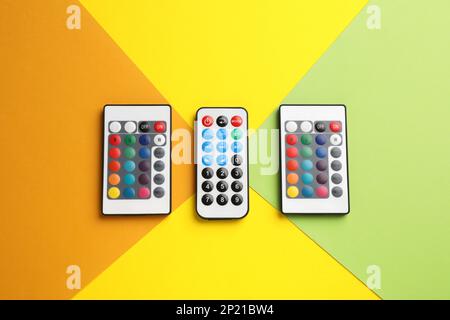 Different remote controls on color background, flat lay Stock Photo