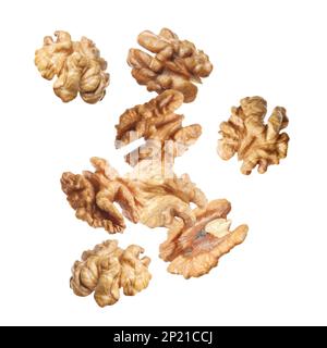 Halves of walnuts falling on white background Stock Photo