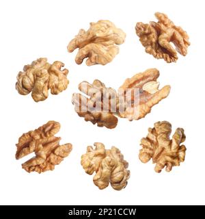 Halves of walnuts falling on white background Stock Photo