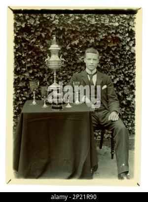 Original Victorian photograph of gent, on a table there is displayed a large Worcester challenge vase, / regatta trophy for rowing, and other cups, Possibly member of a coxed four crew. Worcester area, U.K.  circa 1897-1899. Stock Photo