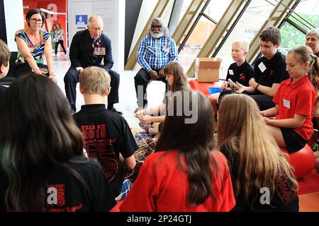 Britain's Prince Charles, second from left at top, speaks with children who are doing a craft with traditional and master basket maker Abe Muriata, top right, from the Girramay aboriginal tribe during a visit to the National Museum of Australia in Canberra, Australia, Wednesday, Nov. 11, 2015. Prince Charles and his wife Camilla, the Duchess of Cornwall, are on a six-day visit to Australia. (Stefan Postles/Pool via AP)