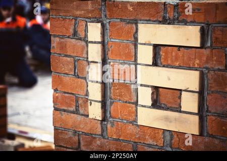 Number sixteen freshly made of white bricks in a red wall, showing the constructor skills. Big characters 16 embossed in a brick wall indicating the Stock Photo