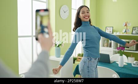 Young beautiful hispanic woman dancing recording online tutorial for social networks at home Stock Photo
