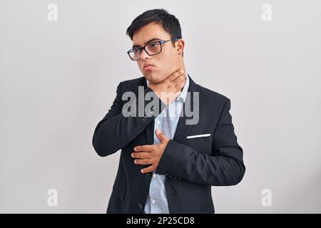 Young hispanic man with down syndrome wearing business style shouting and suffocate because painful strangle. health problem. asphyxiate and suicide c Stock Photo