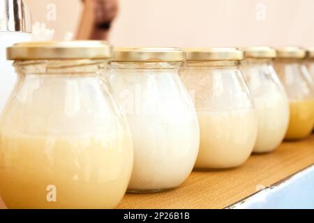 Row of glass jars with honey at a farmers food market. Many bottles with sweet natural honey of various types for sale Stock Photo