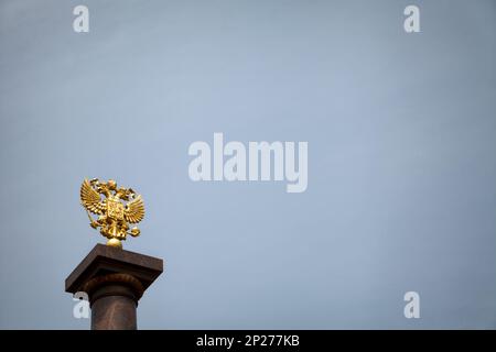 Coat of arms of Russia, golden two-headed eagle against the blue sky. Gold Russian heraldic symbol background with copy space Stock Photo