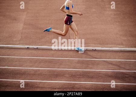 Chelyabinsk, Russia - June 4, 2022: runner girl in spikes shoes and shorts Nike running middle distance at stadium during UFD Athletics Championship Stock Photo