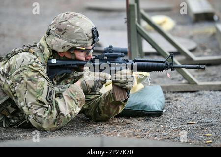 U.S. Army Maj. Edward Fitzpatrick with 207th Military Intelligence Brigade fires an M4 carbine during the brigade’s yearly exercise Lightning Focus at the 7th Army Training Command’s Grafenwoehr Training Area, Germany, Jan. 24, 2023. Lightning Focus 2023 provides an opportunity for increasing individual & crew weapons proficiency, training on Basic Soldier Skills, junior Soldier and NCO development, improving unit cohesion & team-building, and scenario-based operational intelligence support training to certify intelligence platforms; building readiness in support of SETAF-AF, USAREUR-AF and US Stock Photo