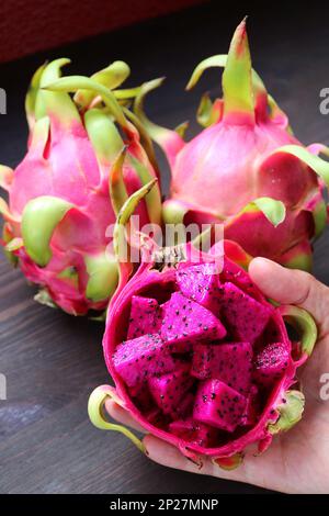 Diced Ripe Pink Pitaya or Red Flesh Dragon Fruit with Blurry Whole Fruits in the Backdrop Stock Photo