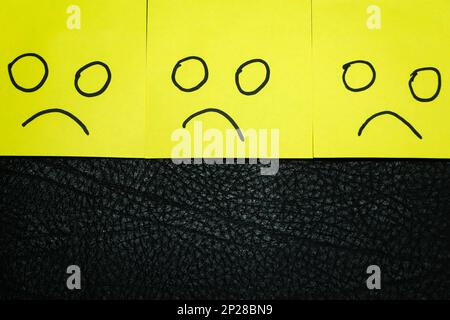 Emotions concept. Background of sticky notes. Green sticky note is among yellow sticky notes. Stock Photo