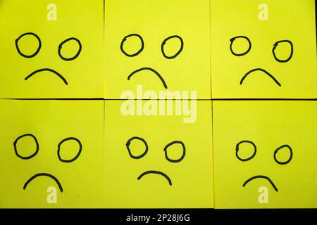 Happy and unhappy concept. Background of green sticky notes. Happy sticky note is among unhappy sticky notes Stock Photo