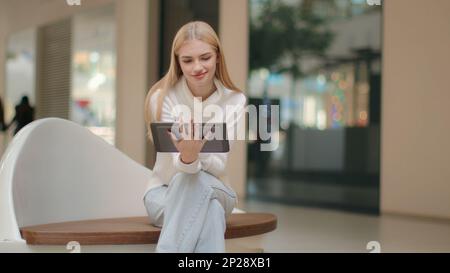 Freelancer woman self-employed worker sit in shopping business center Caucasian girl businesswoman female manager of internet store use gadget digital Stock Photo