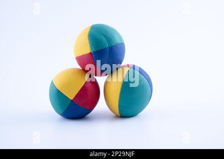 set of three brightly colored leather hand made and stitched professional juggling balls isolated on a white background Stock Photo
