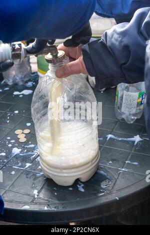 Filling up large bottle with fresh milk. Dairy farmers protesting