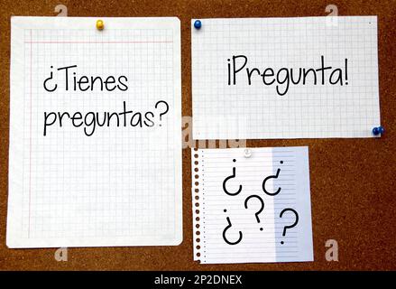 White and colored notes on cork board with message in spanish 'Do you have a question?' Stock Photo