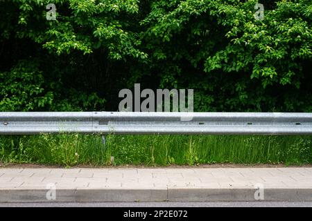 Closeup view of a metal guardrail and support posts along an urban ...
