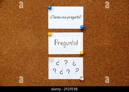 White and colored notes on cork board with message in spanish 'Do you have a question?' Stock Photo