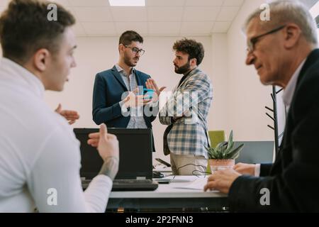 One of the two businessmen is disagreeing with the others offer in the office workspace Stock Photo