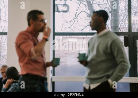 Two diverse coworkers making a plan for their next client on the internet at the office Stock Photo