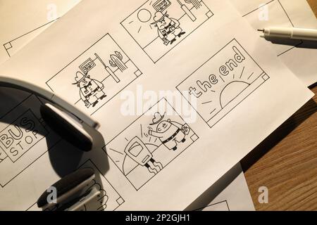 Lay Pattern Process Cartoon Storyboards with cartoon sketches at workplace, flat lay. Pre ...